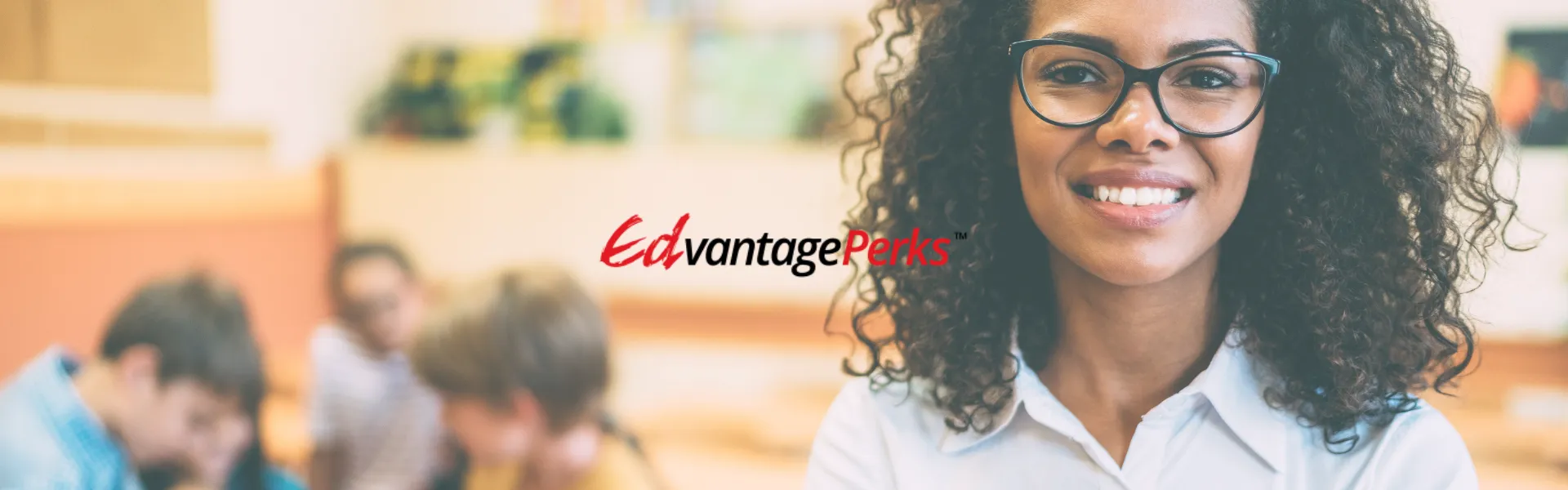 Black female teacher in the foreground with a group of students in the background. The Edvantage Perks logo is placed in the centre. 